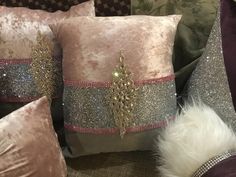 three decorative pillows on a couch with some furnishing in the corner and one has a christmas tree on it