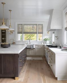 a kitchen with wooden floors and white walls, along with an island in the middle