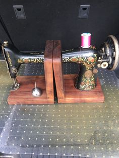 an old sewing machine is on display in the back of a car, with two spools of thread next to it