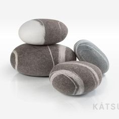 three rocks stacked on top of each other with white and gray stripes in the middle