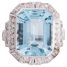 Art Déco style ring with an octagonal faceted aquamarine weighing approx. 12.00 ct, with a beautiful blue color. Set and surrounded by 34 diamonds with a total weight of approx. 0.60 ct. Ring made of 14-carat white gold. Product weight: 8.43 g, Ring size: 18 (58), Origin: Western Europe, first half of the 20th century. Good condition, traces of use appropriate to the age of the item. A classic, geometric form characteristic of the Art Deco style. A beautiful accessory for women who appreciate timeless jewelry 1910s Engagement Ring, Vintage Halo Ring, Retro Engagement Rings, Contemporary Engagement Rings, Platinum Diamond Engagement Rings, Art Deco Diamond Rings, Diamond Halo Ring, Gold Cocktail Ring, Art Deco Engagement