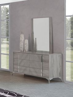 a large mirror sitting on top of a dresser next to a wall mounted vases