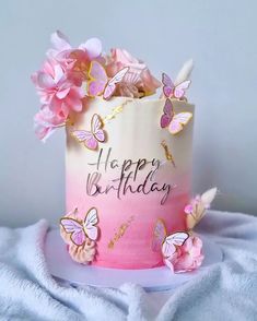 a pink and white birthday cake with butterflies on it