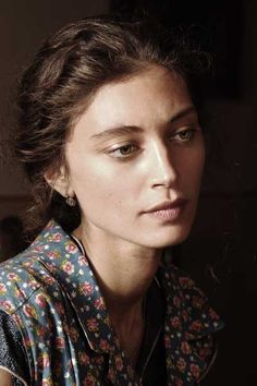 a close up of a person wearing a shirt and looking off to the side with a serious look on her face