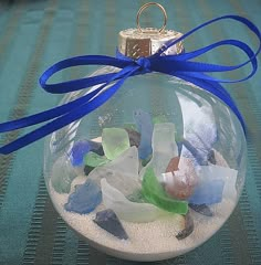 an ornament filled with sea glass and blue ribbon