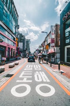 a city street with people walking and cars driving down it