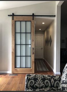 a living room with a couch, chair and sliding glass door that leads to the hallway