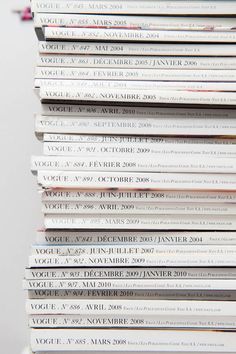 a stack of books sitting on top of each other in front of a white wall