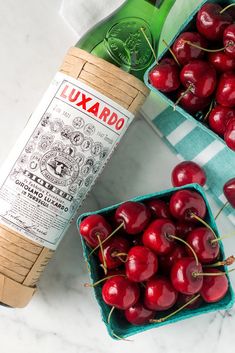 some cherries and a bottle of wine on a table