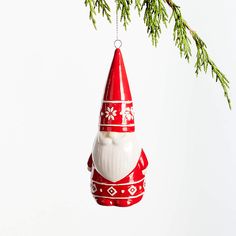 a red and white christmas ornament hanging from a tree