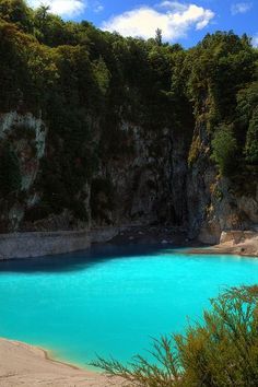 a blue lake surrounded by trees and cliffs