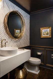 a bathroom with black walls and gold accents