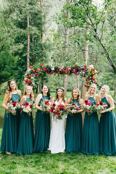 a group of bridesmaids in green dresses holding bouquets