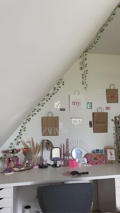 a desk with many items on it under a slanted ceiling