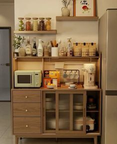 a kitchen area with shelves, microwave and refrigerator