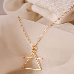 Jewelry with Meaning Triangle Necklace | For Air Signs DESIGNER'S NOTES: Easy to wear and stylish, this design fuses traditional motifs and modern elements, resulting in a great meaningful everyday necklace. This symbol stems back to Grecian times when alchemists used it as a short-hand for the element of Air. Key Features: Symbolic Design: Symbolizes the element of air which is associated with thought, intellect, and innovation. Understated Elegance: Cast in a fetching gold or cool, silver-tone Air Symbol, Element Of Air, Short Hand, Element Necklace, Meaningful Necklace, Air Signs, Symbols And Meanings, Traditional Motifs, Modern Elements