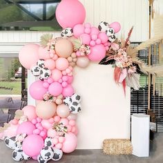 the balloon arch is decorated with pink, white and black balloons