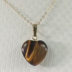 Brand New Solid Yellow Gold (not plated, not bonded) Tiger-eye Pendant This simple and beautiful tiger-eye pendant featuring artisan hand crated in 14k yellow solid gold cup bale. The tiger-eye gemstone was hand ground and polished from natural tiger eye rough beautiful golden-brown into a heart shaped. The tiger-eye itself size has approximately 12mm width by 12mm height. Now available with your choice of: Option A: Pendant only *Chain Not Included Option B: Pendant & Chain included this 16 inc Tiger Eye Pendant, Tiger Eye Necklace, Brown Heart, Beautiful Tiger, Pearl Jewels, Option B, Tigers Eye Necklace, Gold Cup, Tigers Eye Gemstone