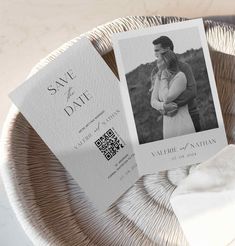 two save the dates cards sitting on top of a plate