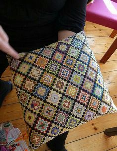 a woman is holding a decorative pillow on the floor