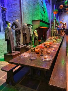 a long table with many items on it in front of some statues and other decorations