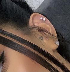 a close up of a person with ear piercings on their ears and behind the ear