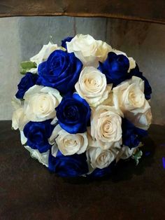 a bouquet of white and blue roses on a table