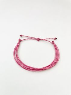 This fun and simple pink string bracelet is waterproof and adjustable, making it great for anyone who is often doing outdoor activities. It would make a nice gift. Stack it with other bracelets, or wear it by itself! It is perfect for everyday wear! ∙ ∙ ∙ ∙ ∙ ∙ ∙ ∙ ∙ ∙ ∙ ∙ ✦ PLEASE NOTE ✦ When you first receive this bracelet, it may feel slightly waxy, which may make it more difficult to adjust. The waxy texture does not last. After a day or two of wearing, the waxy texture will fade, and it wil Adjustable Pink Friendship Bracelets, Pink Adjustable Cord Braided Bracelet, Adjustable Pink Resizable Braided Bracelets, Adjustable Resizable Pink Braided Bracelets, Handmade Pink Nylon Cord Friendship Bracelets, Pink Adjustable Friendship Bracelets Made Of Nylon Cord, Adjustable Pink Friendship Bracelets In Nylon Cord, Adjustable Pink Friendship Bracelets Made Of Nylon Cord, Pink Nylon Cord Bracelets For Beach