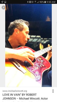 a man is playing an acoustic guitar