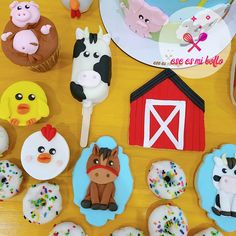 cupcakes decorated with farm animals and farm animals on top of a wooden table