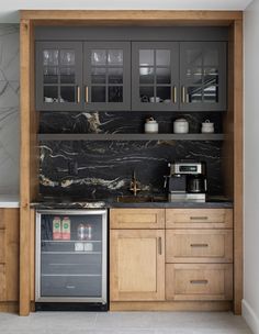 a kitchen with marble counter tops and wooden cabinets, along with stainless steel appliance