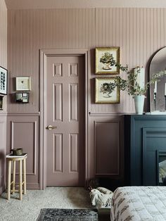 a bedroom with pink walls and pictures on the wall