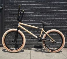 a wooden bike parked next to a brick wall