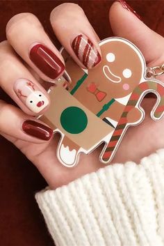 a woman holding up a christmas sticker with a ginger on it's face