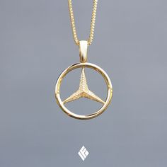 a gold pendant with a diamond in the center on a gray background and an eiffel tower logo