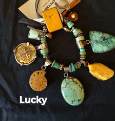 an assortment of jewelry is displayed on a black cloth with the words lucky written below it