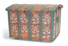 an old wooden chest with painted flowers on it's sides and metal bars at the top