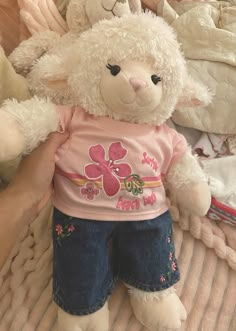 a white stuffed animal sitting on top of a bed