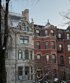 two large brick buildings with snow on the ground