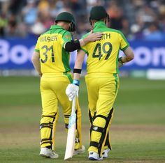 two men in green and yellow uniforms standing next to each other with their arms around one another