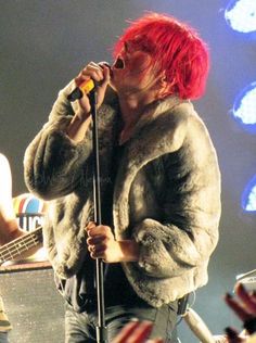 a man with red hair singing into a microphone