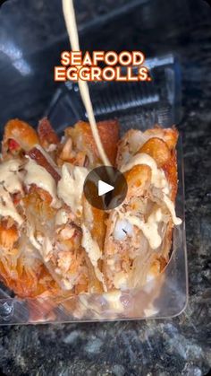 an image of seafood eggrolls being drizzled with sauce