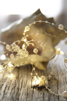 a bunch of lights that are on top of a wooden table with shells and seashells in the background