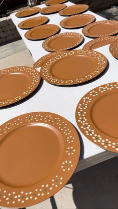 brown plates sitting on top of a table covered in white and gold polka dot paper