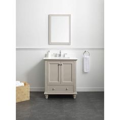 a bathroom vanity with a mirror above it and a towel rack on the wall next to it