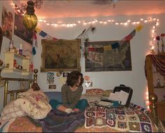 a woman sitting on top of a bed in a room filled with pictures and lights