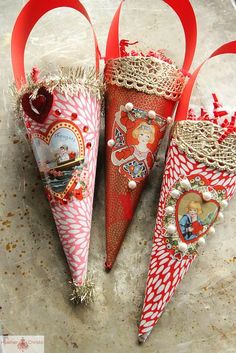 three red and white cones are sitting on the ground with ribbons around them that have been decorated