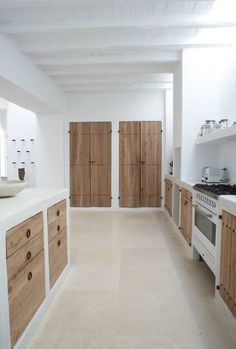 a kitchen with white walls and wooden cabinets