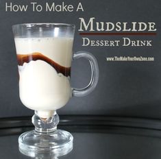 a glass mug filled with liquid sitting on top of a black table next to a sign that says how to make a mudslide dessert drink