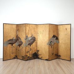 four panel screen with cranes and bamboos on the floor in front of a white wall